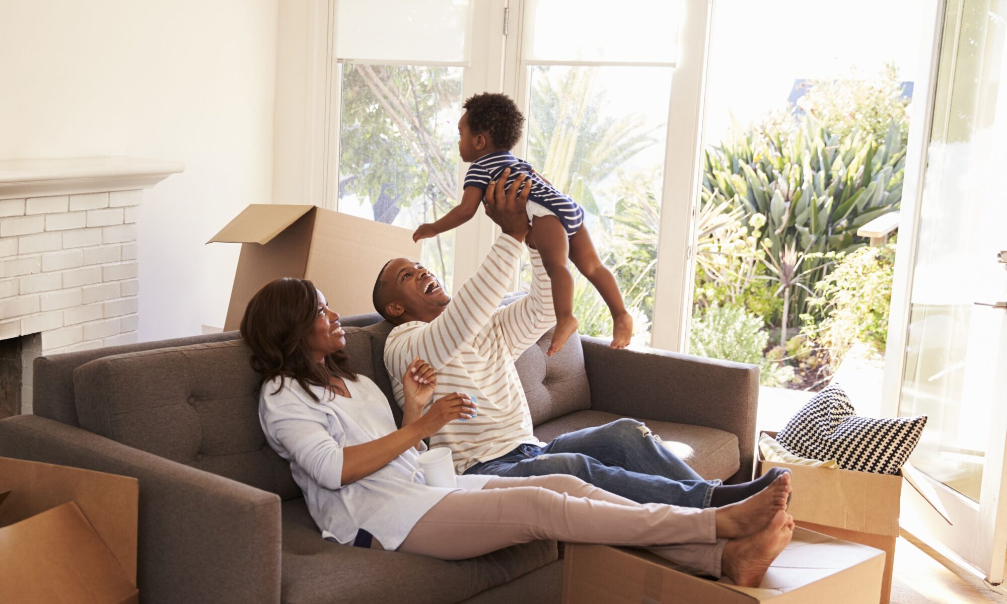 Parents Take A Break On Sofa With Son On Moving Day